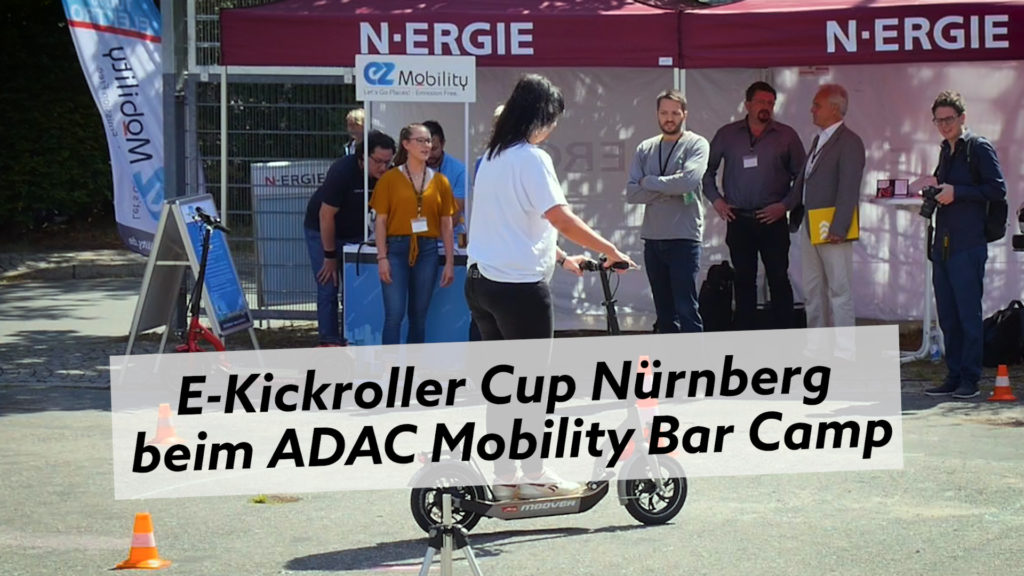 E-Kickroller Cup Nürnberg: Frau auf E-Roller vor N-ERGIE Zelt. Elektromobilität im Fokus.