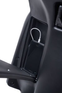 Ray 7.7 Premium E-Roller: Smartphone mit Ladekabel im Ablagefach.