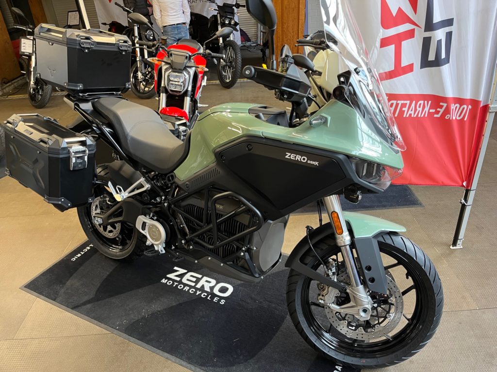 E-Motorrad Zero DSR/X auf Jura-Bike 2023. Gepäckboxen, grüne Verkleidung. Electric Horses.