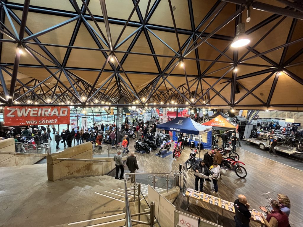 Franken-Bike 2023: Messehalle mit Motorrädern und Ständen, darunter Electric Horses. Viele Besucher.