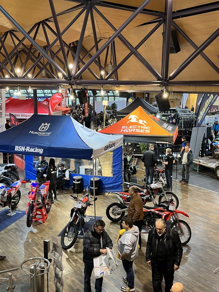 Electric Horses Stand auf der Franken Bike 2023: E-Motorräder unter orangem Zelt mit Logo.