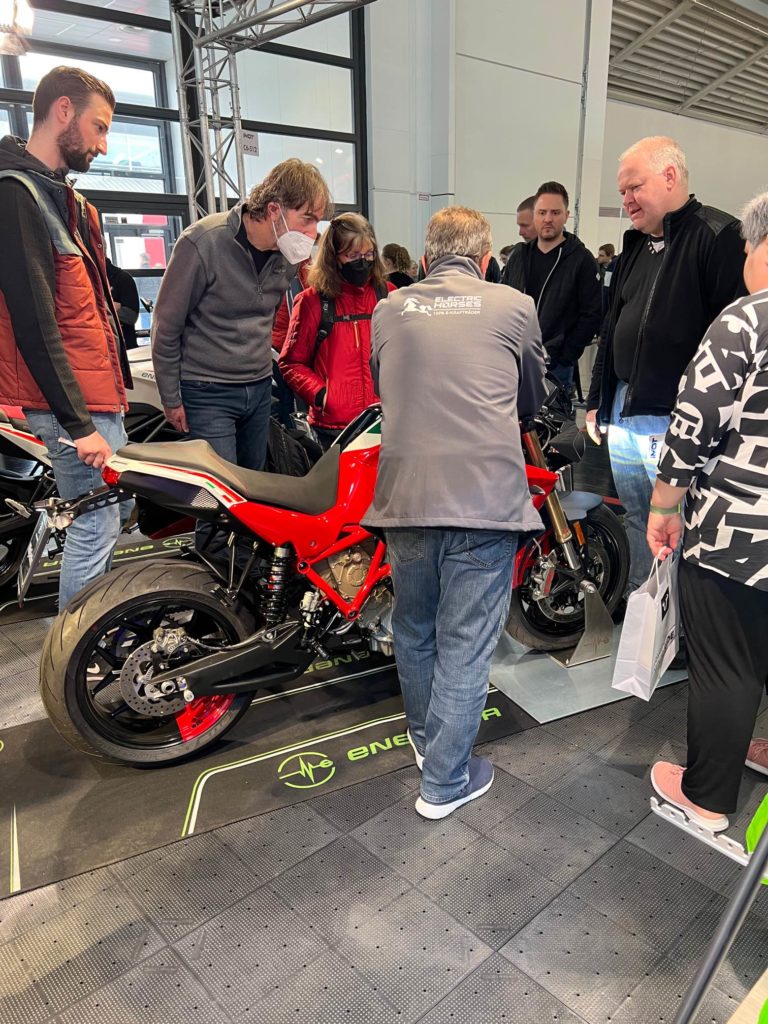 Energica E-Motorrad auf IMOT: Publikum umringt rotes Modell von Electric Horses.