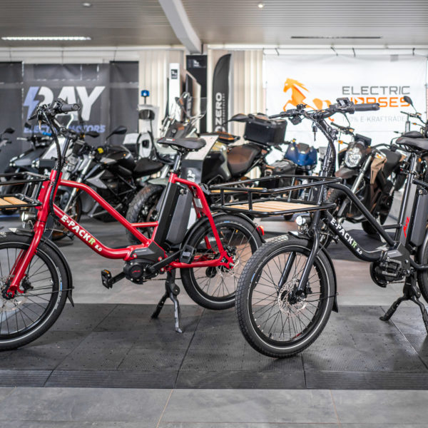 E-Packr 8.0 E-Bikes in Rot und Schwarz vor E-Motorrädern im Verkaufsraum von Electric Horses.