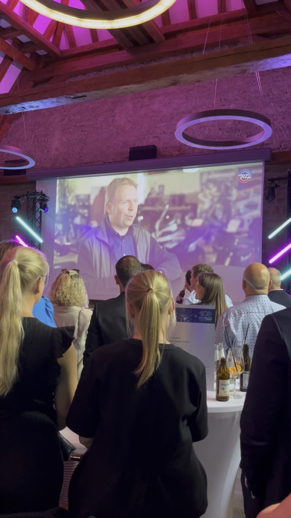 Preisverleihung Automotive Business Award 2024 an Autohaus Richter & Zech/Electric Horses. Publikum vor Leinwand.